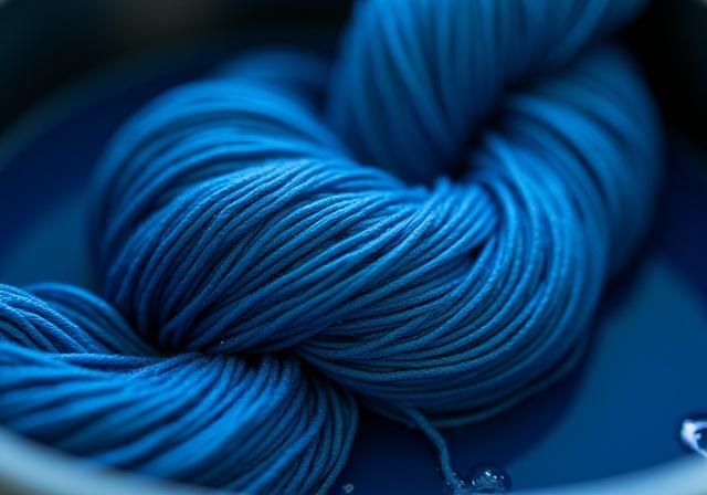 深く美しい藍色の染料で染められた絹糸のクローズアップ。草木染め